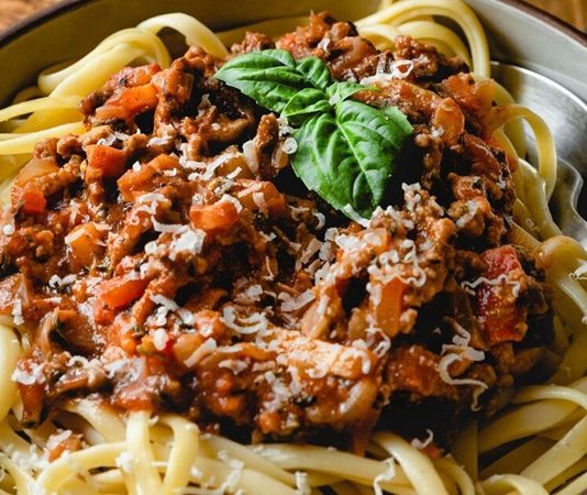 İtalyan Mutfağının Efsane Lezzeti Spagetti Bolonez’in Sırları Klasik İtalyan Mutfağının Taçsız Kralı Spagetti Bolonez'in Sırrı ve Hikayesi Spagetti Bolonez, dünya mutfaklarının en popüler ve sevilen yemeklerinden biridir. İtalya'nın Bolonya bölgesinden çıkan bu klasik tarif, sadece bir yemek olmaktan öte, nesiller boyu aktarılan bir mutfak kültürü mirasıdır. Basit gibi görünse de, gerçek bir Bolonez sosu hazırlamak, sabır, doğru malzemeler ve belirli pişirme teknikleri gerektirir. Bu lezzetli yemeğin ardındaki derin hikayeyi ve onu bu kadar özel yapan incelikleri keşfetmeye hazır olun. Konulu bir haber görseli.