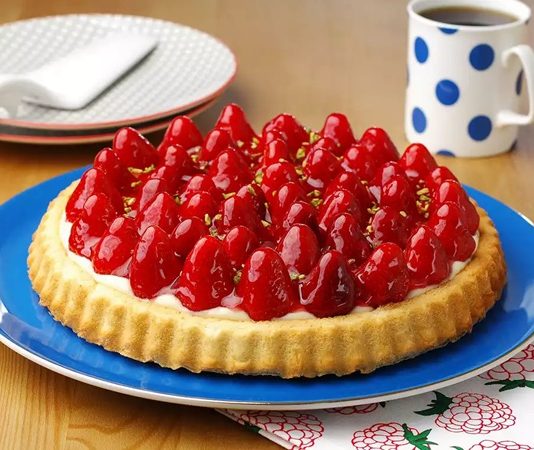 Tatlı dünyasında hem görselliği hem de ferah tadıyla özel bir yere sahip olan çilekli tart, son yıllarda yeniden yükselen bir ilgiyle karşılanıyor. Özellikle mevsiminde kullanılan çileklerin aromasıyla birleşen bu klasik tatlı, hem ev mutfaklarında hem de pastanelerde sıkça tercih ediliyor. İnce tabanı, yumuşak kreması ve taze meyve dokunuşuyla öne çıkan çilekli tart, ağır tatlılardan kaçınanlar için dengeli bir alternatif sunuyor. Konulu bir haber görseli.