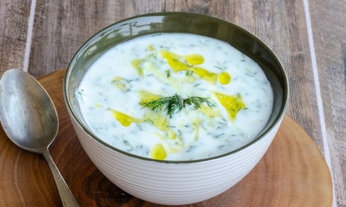 Soğuk Yoğurtlu Kabak Çorbası Yaz Sofralarının Ferahlatıcı Lezzeti Soğuk yoğurtlu kabak çorbası, özellikle yaz aylarında sofraların vazgeçilmez başlangıcı olarak öne çıkıyor. Hafif ve ferahlatıcı bir tarif olan bu çorba, hem besleyici hem de pratik oluşuyla mutfakların favorisi hâline geliyor. Soğuk yoğurtlu kabak çorbası, taze kabak ve yoğurt ile hazırlanırken içerisine eklenen dereotu ve baharatlar çorbanın lezzetini artırıyor. Yaz sofralarında hem aile yemeklerinde hem de davet sofralarında tercih edilen bir seçenek olarak dikkat çekiyor. Konulu bir haber görseli.