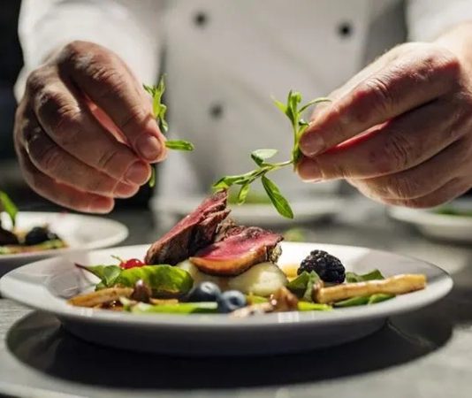 Gastronominin Zirvesinde Yer Alan Fine Dining Restoran Deneyimi Yeme içme kültürü, tarih boyunca toplumların yaşam biçimini ve estetik anlayışını yansıtan önemli alanlardan biri olmuştur. Bu kültürün en rafine noktalarından biri olarak kabul edilen fine dining restoranlar, yalnızca yemek yenilen mekânlar değil, başlı başına birer deneyim alanı olarak öne çıkar. Sunumdan servise, mekân tasarımından menü kurgusuna kadar her ayrıntının titizlikle planlandığı bu restoranlar, gastronomiyi sanatsal bir boyuta taşır. Konulu bir haber görseli.